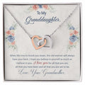 Necklace with interlocking hearts on a floral card with text, displayed in a box.